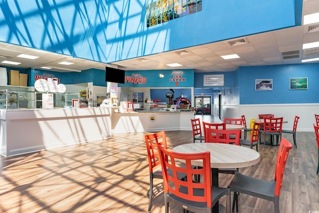 dining area with hardwood / wood-style flooring and a drop ceiling