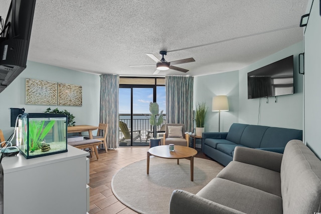 living room with a textured ceiling, light hardwood / wood-style floors, ceiling fan, and floor to ceiling windows