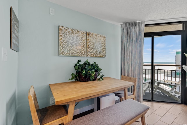 dining space with a textured ceiling and light tile flooring