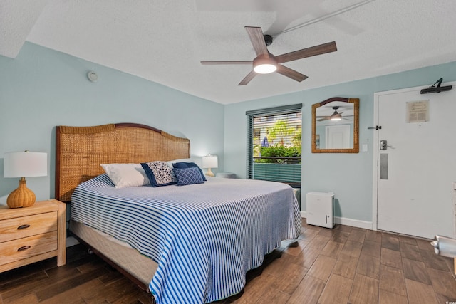 bedroom featuring a textured ceiling, dark hardwood / wood-style floors, and ceiling fan