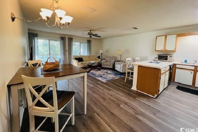 kitchen featuring hanging light fixtures, hardwood / wood-style flooring, ceiling fan with notable chandelier, and sink