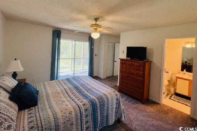 carpeted bedroom with ceiling fan, ensuite bathroom, and a textured ceiling