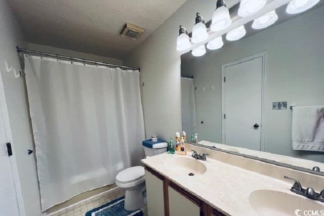 bathroom featuring vanity, toilet, a shower with shower curtain, and a textured ceiling