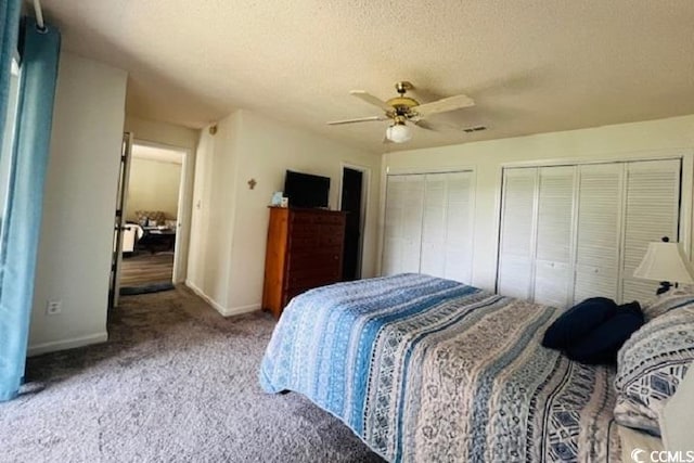 carpeted bedroom with ceiling fan, a textured ceiling, and multiple closets