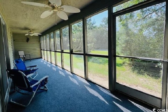 unfurnished sunroom featuring ceiling fan