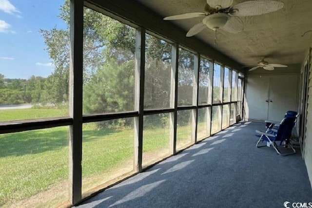 unfurnished sunroom with ceiling fan