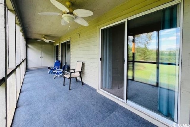 unfurnished sunroom with ceiling fan