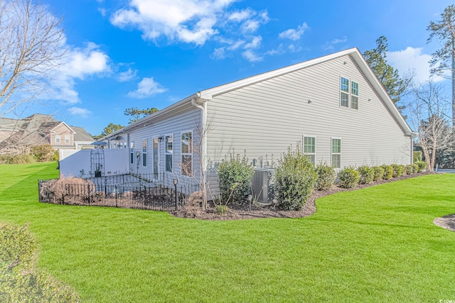 rear view of property with a lawn and central AC