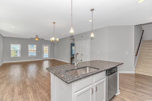 kitchen with sink, stainless steel dishwasher, dark stone countertops, a kitchen island with sink, and white cabinets