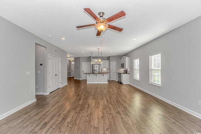 unfurnished living room with hardwood / wood-style flooring and ceiling fan