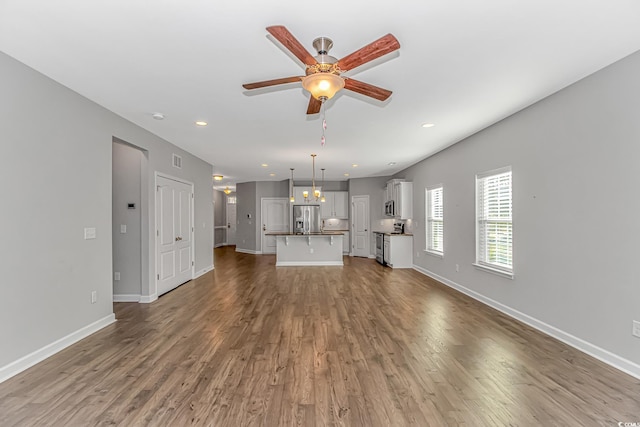 unfurnished living room with hardwood / wood-style flooring and ceiling fan