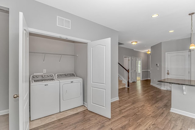 washroom featuring washing machine and clothes dryer and light wood-type flooring