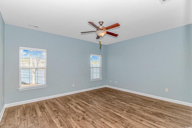 spare room with hardwood / wood-style floors and ceiling fan