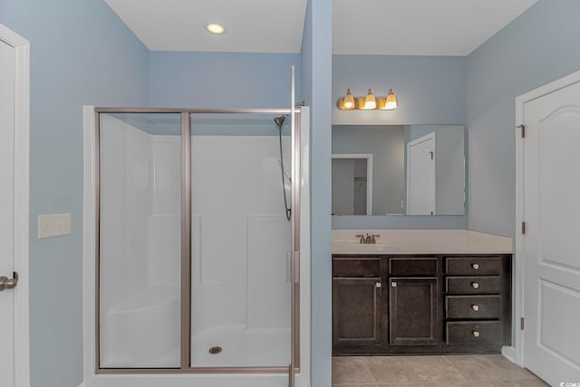 bathroom with tile patterned floors, vanity, and an enclosed shower