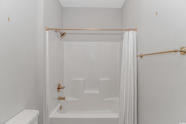 bathroom with shower / bath combination with curtain and toilet