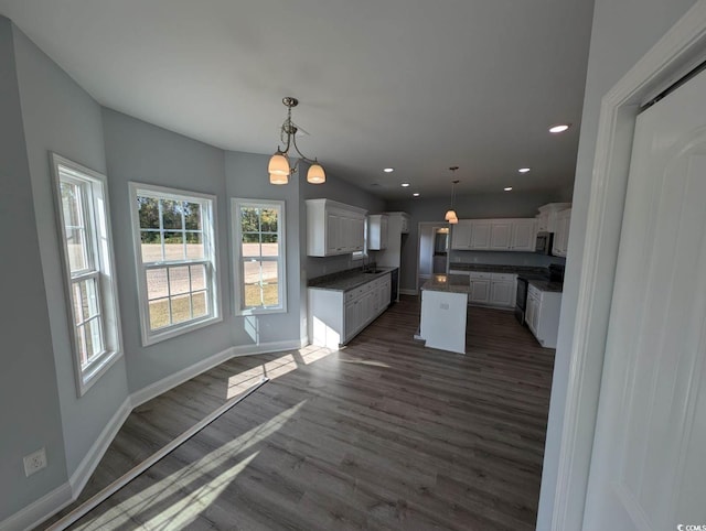 kitchen featuring dark countertops, white cabinets, stainless steel appliances, and dark wood-style flooring