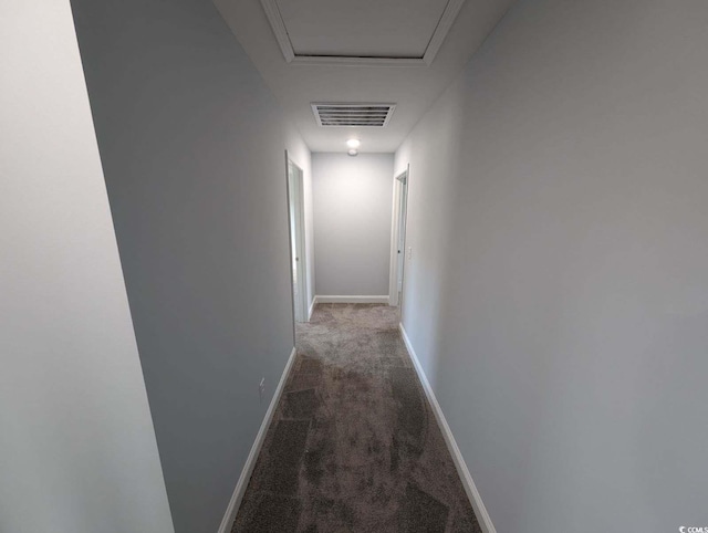 corridor featuring carpet flooring, attic access, baseboards, and visible vents