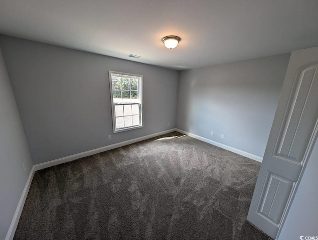 empty room featuring visible vents, carpet, and baseboards