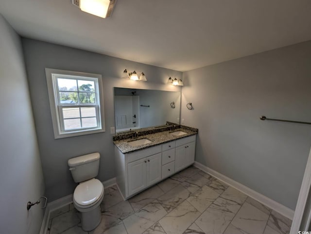 full bathroom with marble finish floor, toilet, baseboards, and a sink