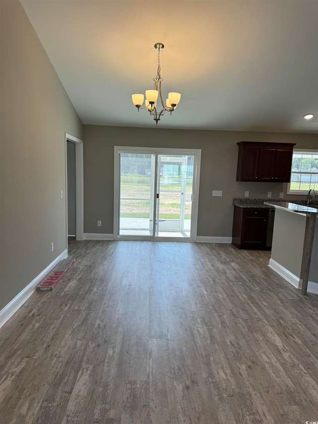 kitchen featuring dark brown cabinets, hanging light fixtures, hardwood / wood-style flooring, and plenty of natural light