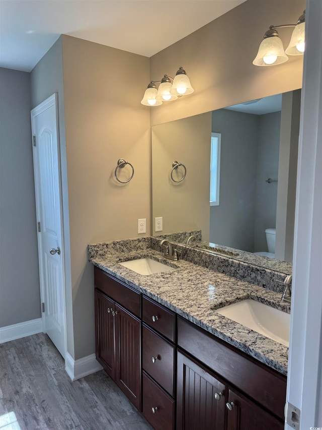 bathroom featuring toilet, hardwood / wood-style floors, and vanity