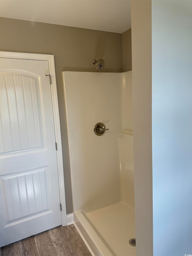 bathroom with walk in shower and hardwood / wood-style floors