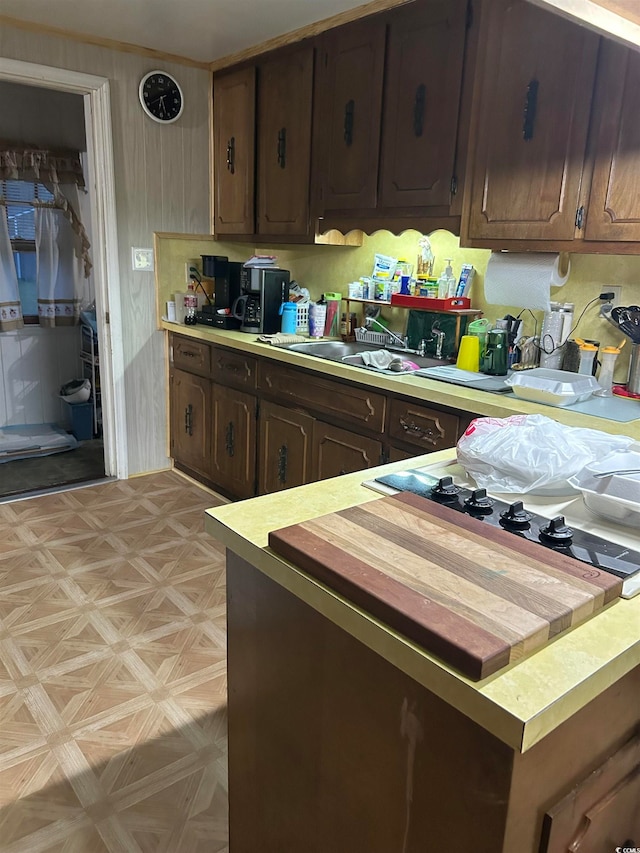 kitchen featuring sink, light parquet floors, and dark brown cabinets