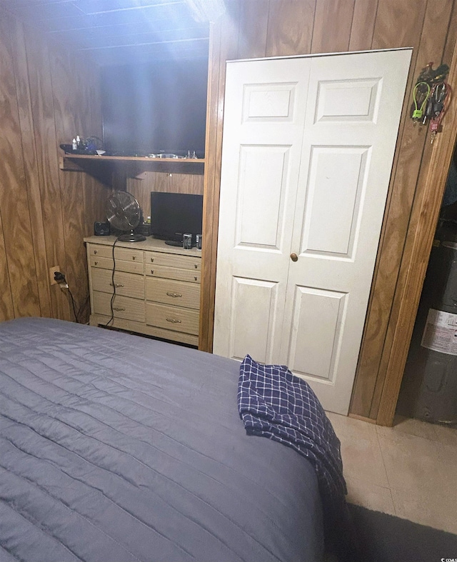 bedroom featuring wood walls, tile flooring, and a closet