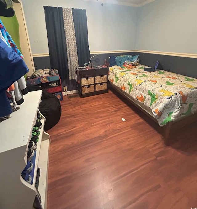 bedroom with hardwood / wood-style floors and crown molding