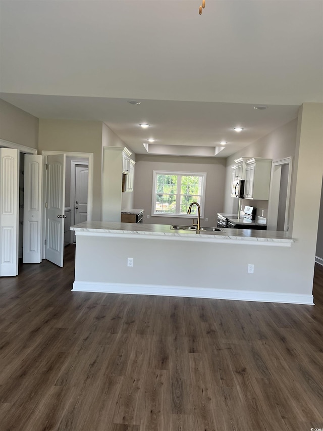 kitchen with dark wood finished floors, a sink, light countertops, white cabinets, and appliances with stainless steel finishes