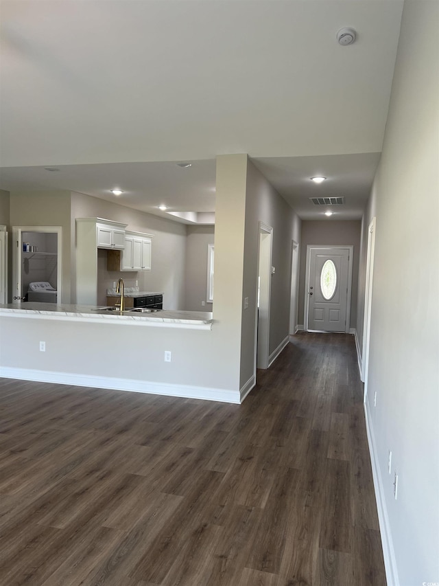 entrance foyer with dark wood-style floors, visible vents, recessed lighting, and baseboards