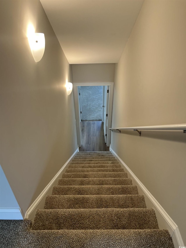 stairs with baseboards and carpet floors