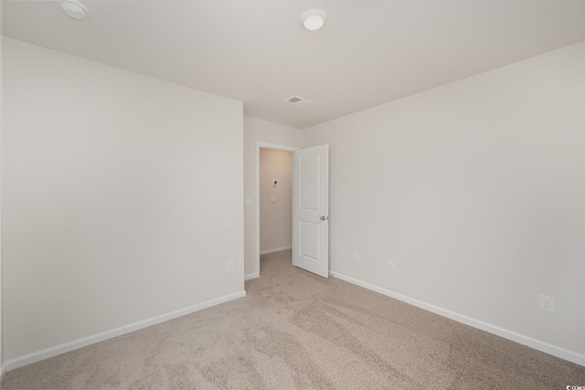 spare room featuring light colored carpet