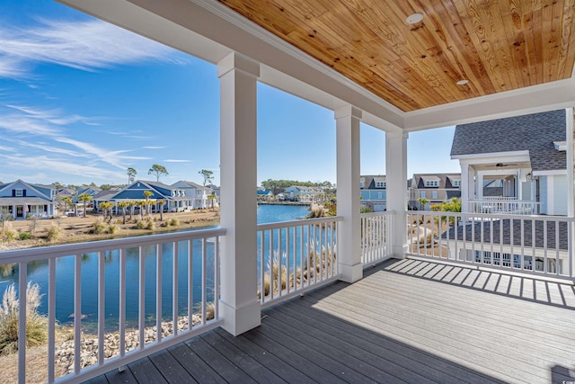 wooden deck with a residential view and a water view