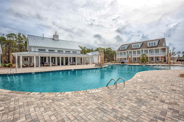 view of swimming pool featuring a patio and an outdoor structure