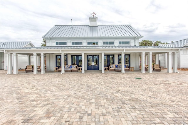 back of house with an outdoor living space and a patio area