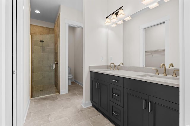 bathroom with baseboards, double vanity, a sink, and a shower stall