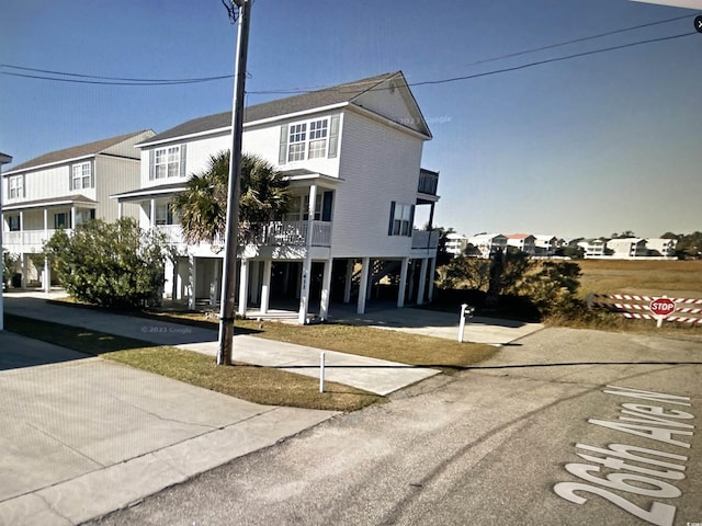 view of front of home with a carport, a residential view, and a balcony