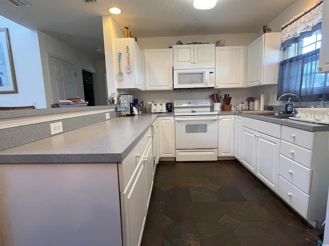 kitchen with white cabinetry, white appliances, a textured ceiling, kitchen peninsula, and sink