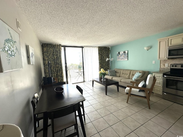 tiled living room featuring a textured ceiling and floor to ceiling windows