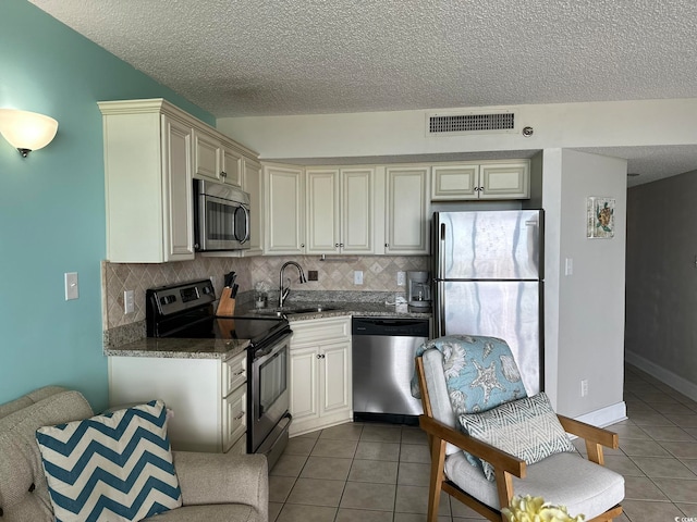 kitchen with sink, light tile floors, tasteful backsplash, and appliances with stainless steel finishes