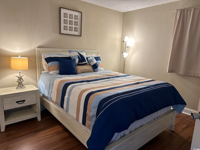 bedroom with dark wood-type flooring and a textured ceiling