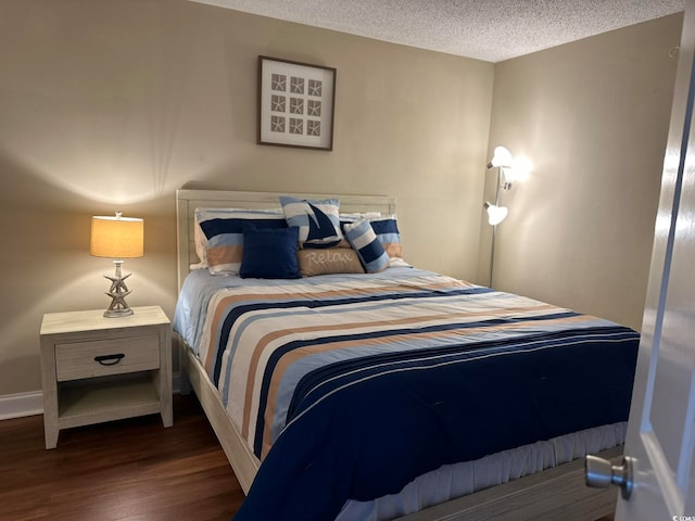 bedroom with a textured ceiling and dark hardwood / wood-style floors