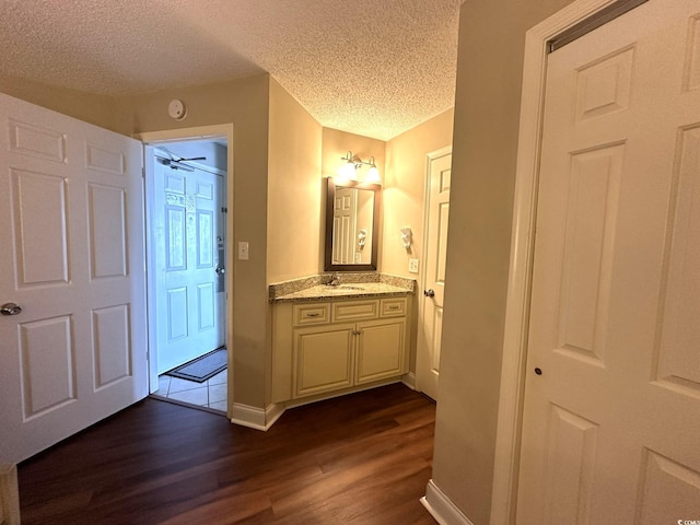 interior space with a textured ceiling, vanity, and hardwood / wood-style floors