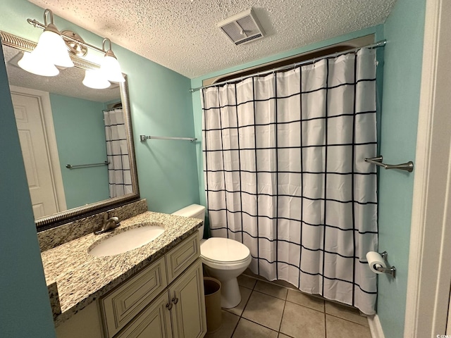 bathroom with a textured ceiling, vanity, toilet, and tile floors