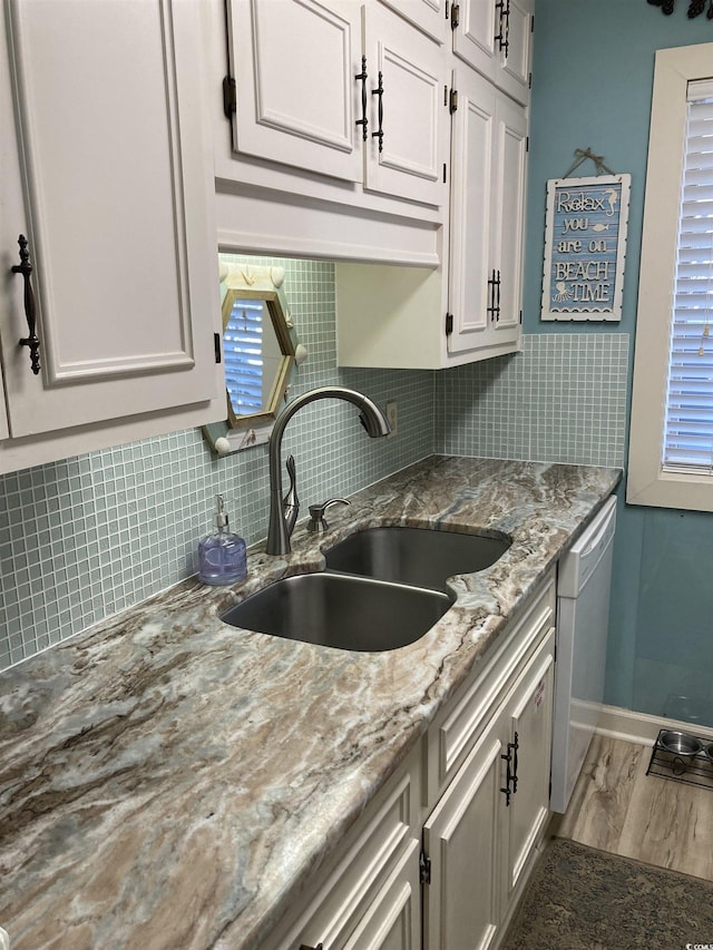 kitchen with white cabinetry, sink, and dishwasher