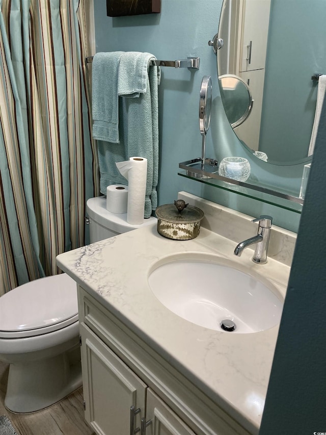 bathroom featuring vanity, hardwood / wood-style flooring, and toilet