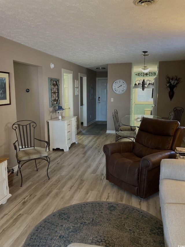 living room with a textured ceiling and light wood-type flooring