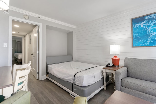 bedroom featuring an AC wall unit, ornamental molding, and hardwood / wood-style floors