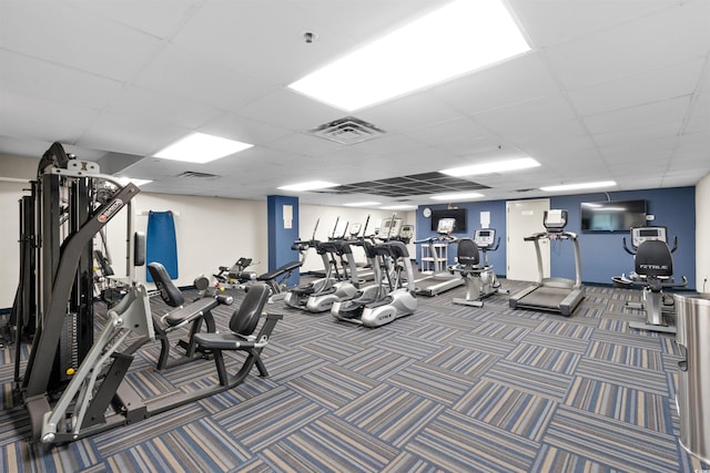 exercise room featuring carpet floors and a paneled ceiling